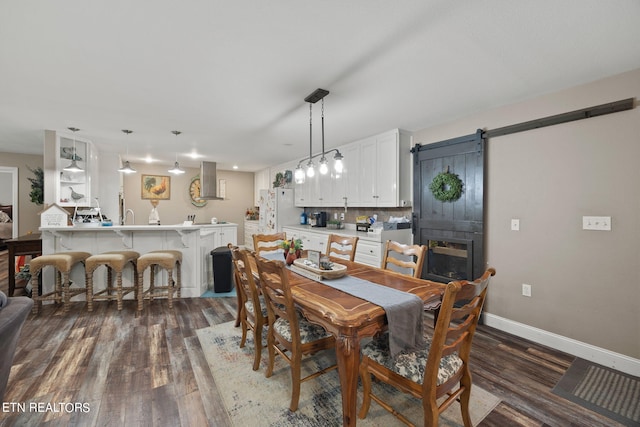 dining area with heating unit, a barn door, and dark hardwood / wood-style floors