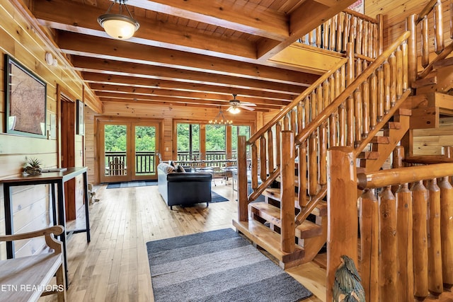 interior space featuring ceiling fan, hardwood / wood-style flooring, wooden walls, and beamed ceiling