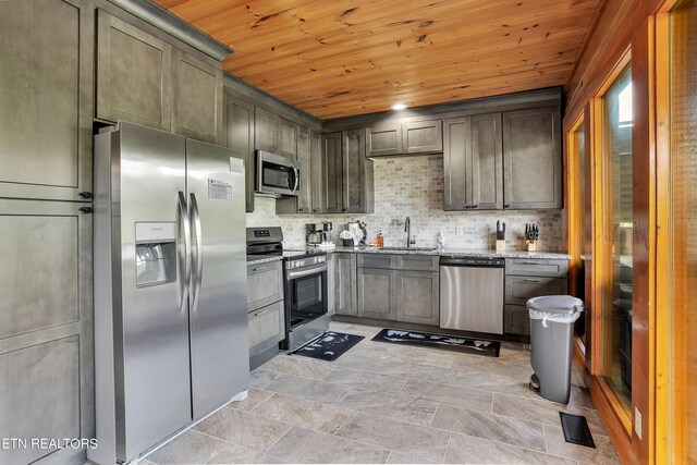 kitchen with light stone countertops, wooden ceiling, appliances with stainless steel finishes, tasteful backsplash, and sink