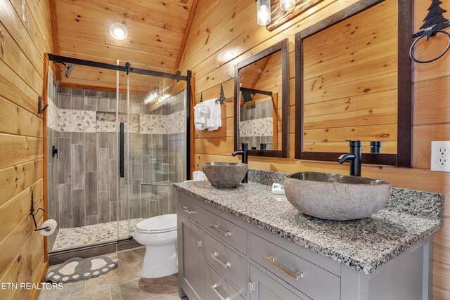 bathroom with a shower with door, wooden walls, vaulted ceiling, toilet, and vanity