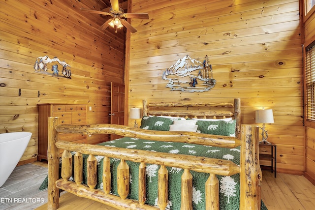 bedroom featuring wood walls and light hardwood / wood-style floors