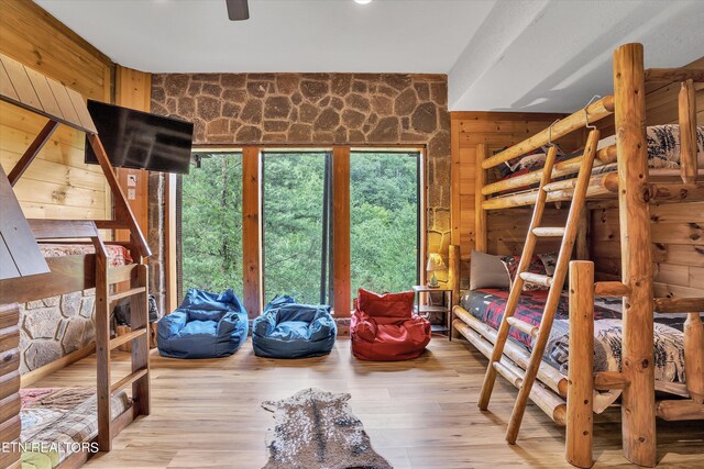 bedroom featuring light wood-type flooring and wood walls