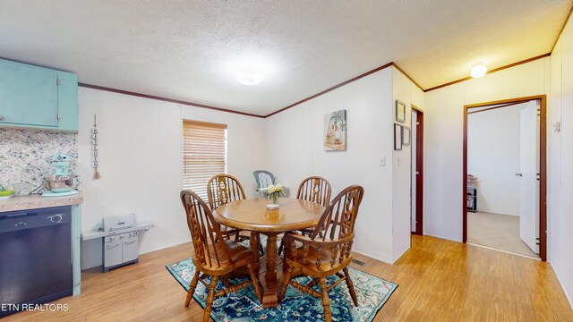 dining area with crown molding, light hardwood / wood-style floors, and a textured ceiling