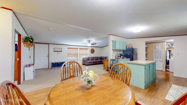 dining space featuring ceiling fan, light hardwood / wood-style flooring, crown molding, and a textured ceiling