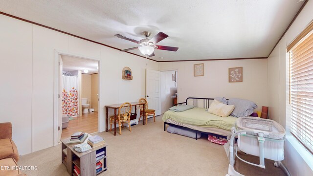 bedroom featuring ceiling fan, crown molding, and light carpet