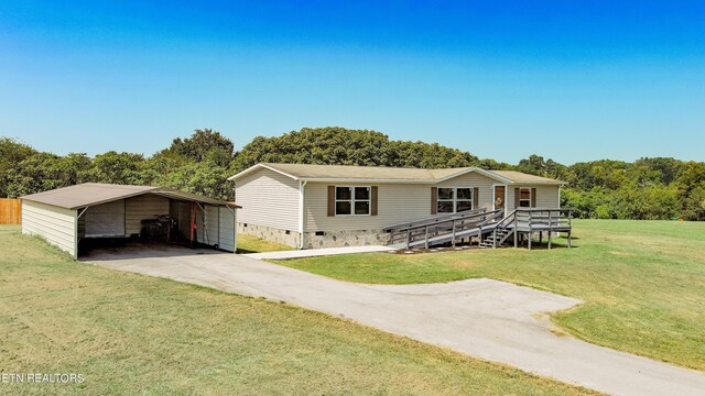 manufactured / mobile home with a front lawn and a carport