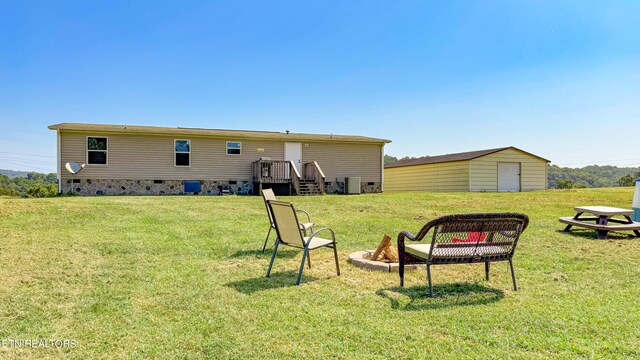 rear view of house with a yard and a storage unit