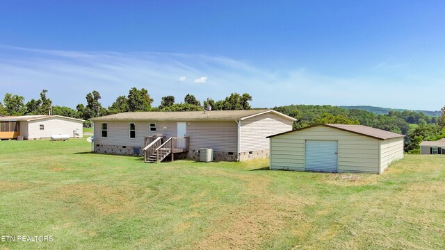 back of house featuring a storage unit, cooling unit, and a yard