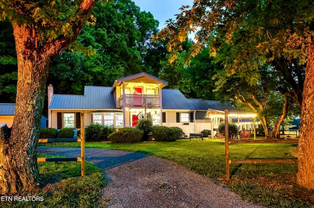 view of front of property with a balcony and a lawn