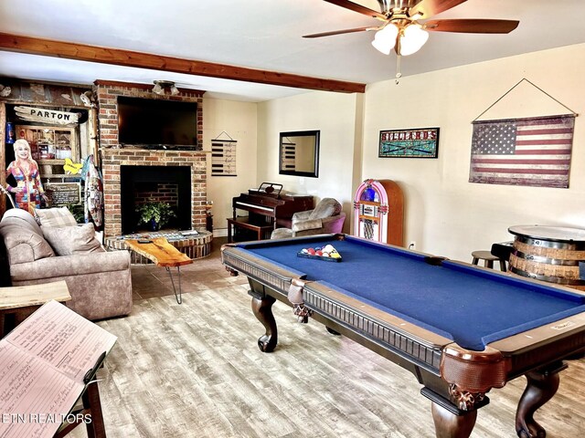 recreation room featuring billiards, a brick fireplace, hardwood / wood-style floors, ceiling fan, and beam ceiling