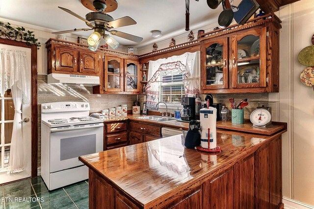 kitchen with white range with electric stovetop, dark tile patterned flooring, backsplash, sink, and ceiling fan