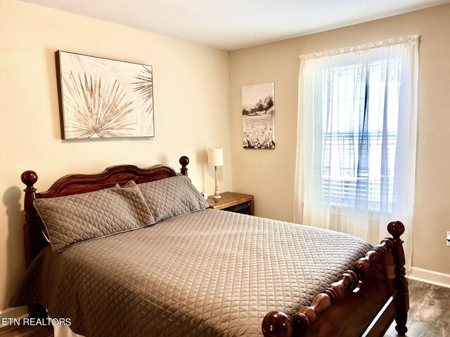 bedroom with dark wood-type flooring