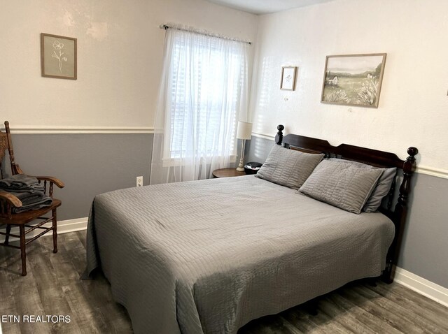 bedroom featuring dark wood-type flooring and multiple windows