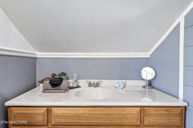 bathroom with vanity and lofted ceiling