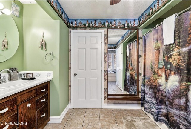 bathroom with a textured ceiling, vanity, and ceiling fan