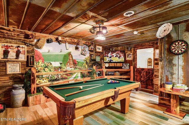 rec room with light wood-type flooring, wood walls, and pool table