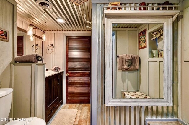 bathroom with vanity, toilet, and hardwood / wood-style flooring