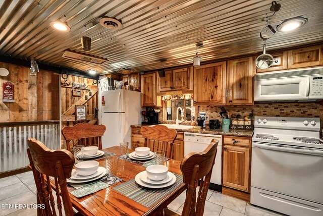 kitchen featuring pendant lighting, white appliances, sink, and light tile patterned flooring