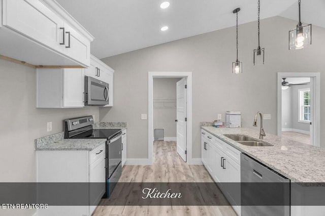 kitchen with appliances with stainless steel finishes, lofted ceiling, sink, and white cabinets