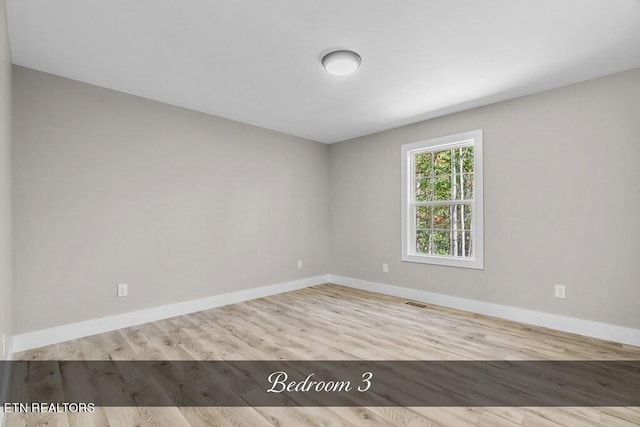 spare room with light hardwood / wood-style flooring