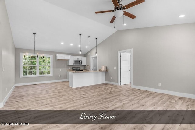 kitchen featuring white cabinets, kitchen peninsula, decorative light fixtures, light hardwood / wood-style flooring, and appliances with stainless steel finishes