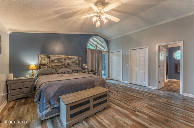 bedroom with a textured ceiling, lofted ceiling, dark hardwood / wood-style flooring, ornamental molding, and ceiling fan