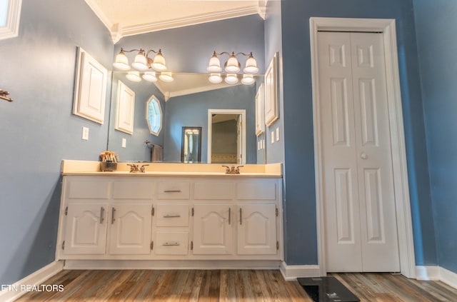 bathroom featuring lofted ceiling, crown molding, hardwood / wood-style floors, and vanity