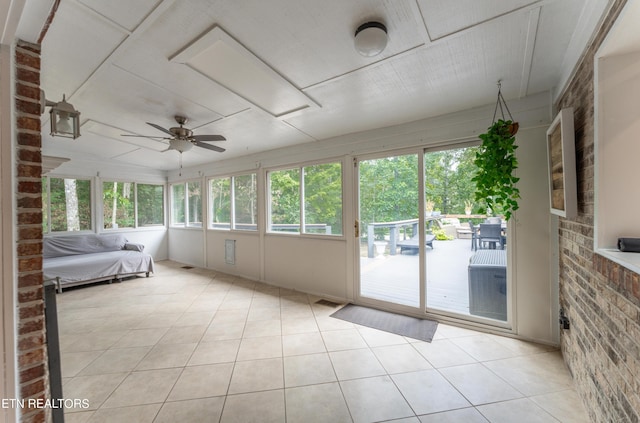 unfurnished sunroom with ceiling fan