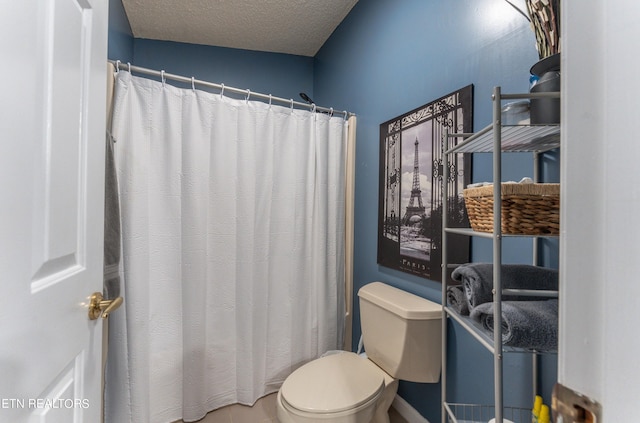 bathroom with a textured ceiling, toilet, and a shower with shower curtain