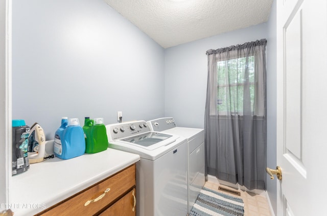 washroom featuring washing machine and dryer and a textured ceiling