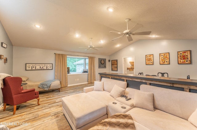 living room featuring ceiling fan, light hardwood / wood-style flooring, and lofted ceiling