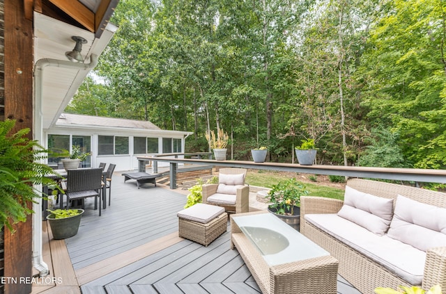 wooden deck with a sunroom and outdoor lounge area