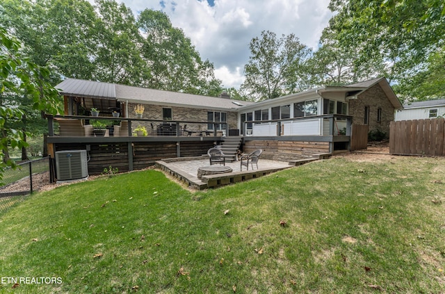 back of house with a deck, a sunroom, a yard, and central AC unit