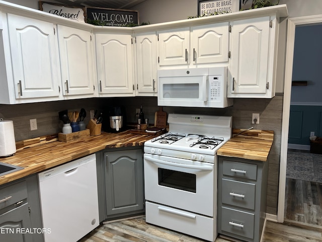 kitchen featuring white cabinets, wooden counters, and white appliances