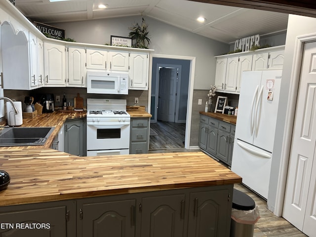 kitchen featuring lofted ceiling, sink, white appliances, white cabinetry, and butcher block counters