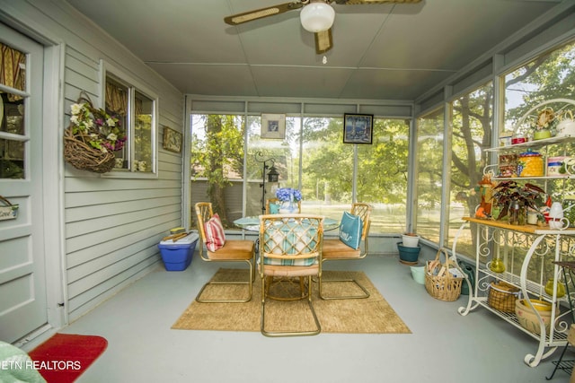 sunroom / solarium featuring a healthy amount of sunlight and ceiling fan