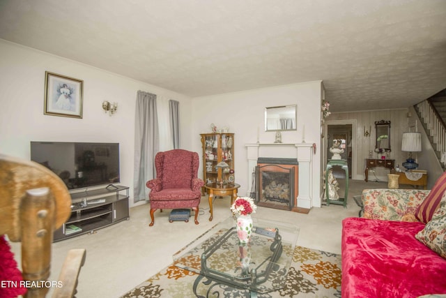 living area with carpet floors, a fireplace, stairway, and a textured ceiling