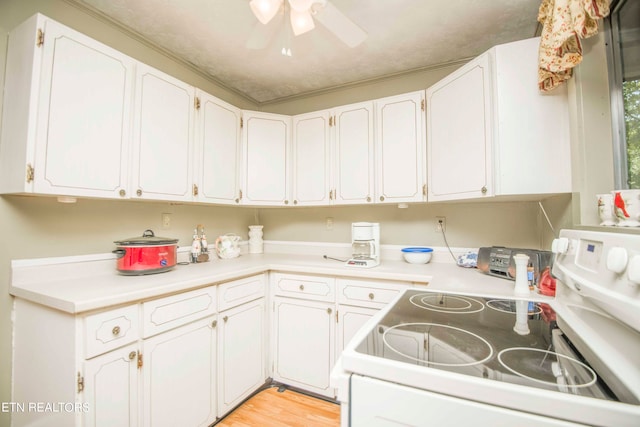 kitchen with light hardwood / wood-style flooring, white electric stove, ceiling fan, and white cabinets