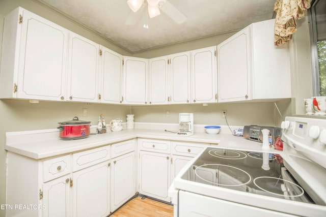 kitchen featuring ceiling fan, electric range, white cabinets, light countertops, and light wood-type flooring