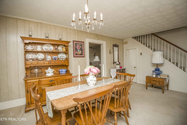 dining room with a chandelier, stairway, baseboards, and light colored carpet