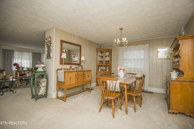 dining space featuring crown molding, a textured ceiling, an inviting chandelier, and light colored carpet