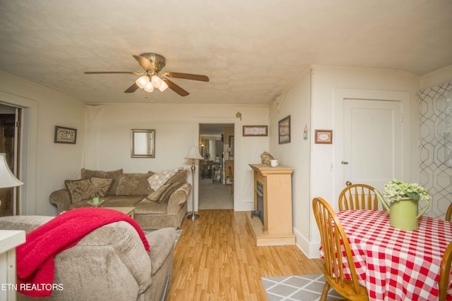 living room featuring light wood-type flooring and a ceiling fan