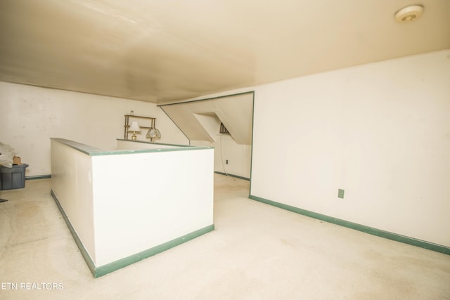 unfurnished room featuring light carpet and baseboards