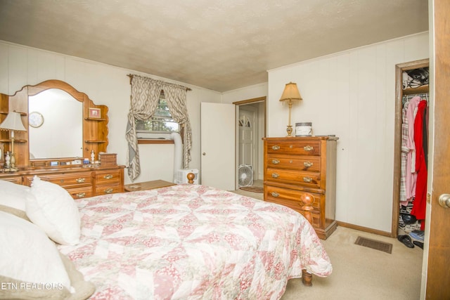 carpeted bedroom featuring ornamental molding, visible vents, a textured ceiling, and baseboards