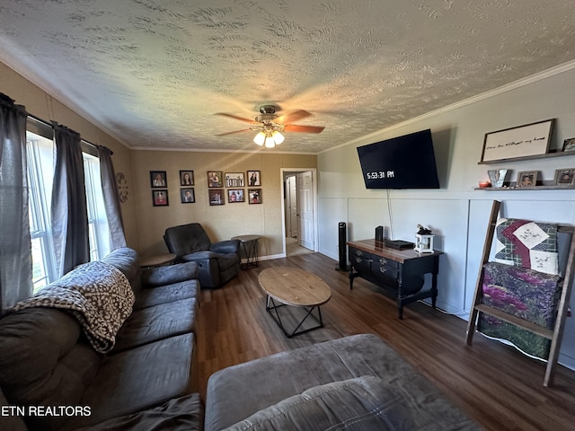 living area with a textured ceiling, ornamental molding, wood finished floors, and a ceiling fan