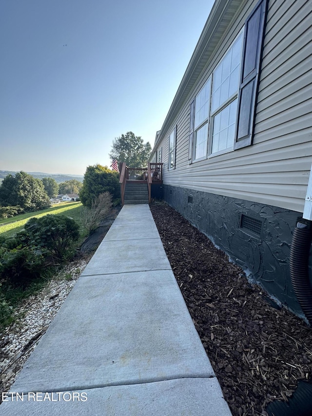 view of side of property featuring a deck and crawl space