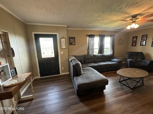 living room with a textured ceiling, a ceiling fan, baseboards, ornamental molding, and dark wood finished floors