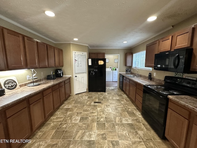 kitchen featuring washer and clothes dryer, ornamental molding, a sink, a textured ceiling, and black appliances