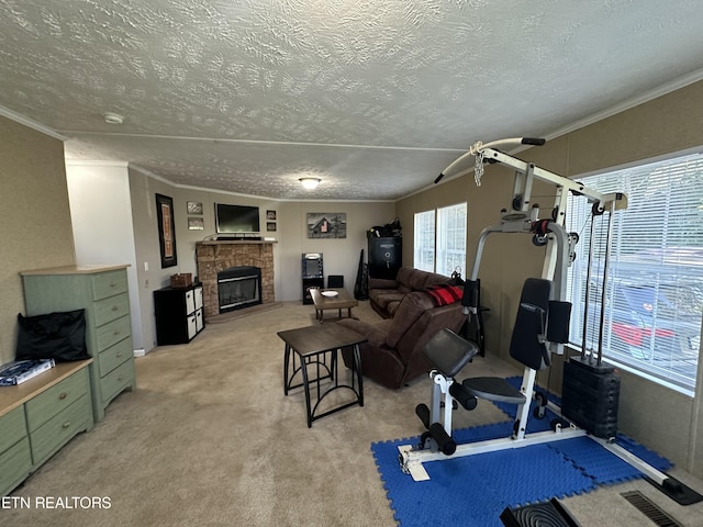 living area with visible vents, light colored carpet, a textured ceiling, crown molding, and a fireplace