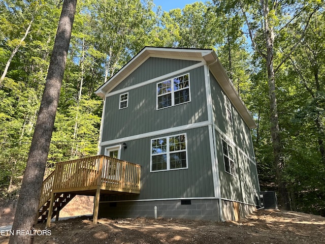 rear view of house featuring central air condition unit and a wooden deck